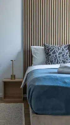 a bedroom with a blue bed with a wooden headboard at Lawa 22 in Kopaonik