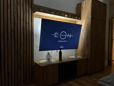 a computer monitor on a table with a bottle of wine at Mance apartments 2 in Paraćin
