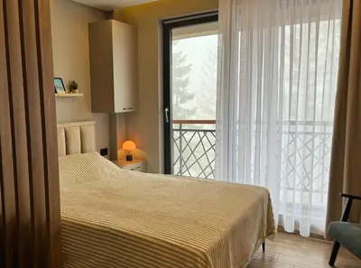 a bedroom with a bed and a large window at Pine apartments Residence Hill in Kopaonik