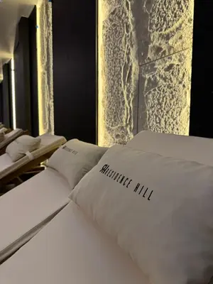 a bed with white pillows on top of it at Pine apartments Residence Hill in Kopaonik