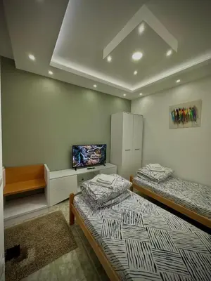 a room with two beds and a tv in it at Lux A2 in Jošanička Banja