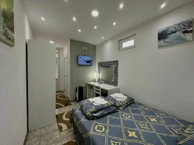 a bedroom with a bed and a sink and a television at Room 4A in Jošanička Banja
