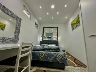 a bedroom with a bed and a vanity and a mirror at Room 4A in Jošanička Banja