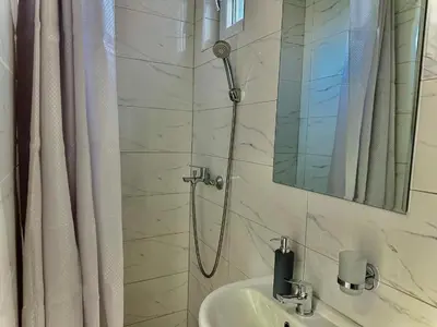 a bathroom with a shower with a sink and a mirror at Room 4A in Jošanička Banja