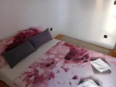 a bedroom with a bed with a pink blanket at Apartment Eleven in Niš