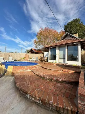 a brick patio with a pool and a house at Brick House