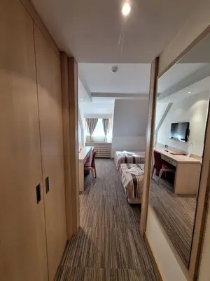 a hotel room with a bed and a desk and a bedroom at Angella Konaci KOPAONIK in Kopaonik