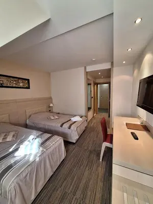 a hotel room with two beds and a flat screen tv at Angella Konaci KOPAONIK in Kopaonik