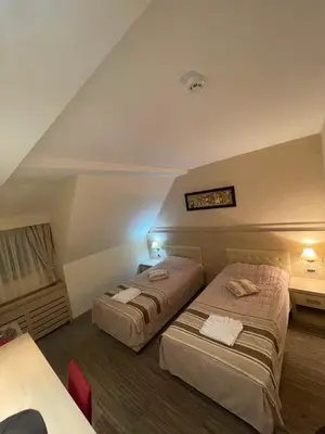 a hotel room with two beds and a table at Angella Konaci KOPAONIK in Kopaonik