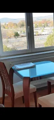 a blue table and two chairs in front of a window at Lux Studio River View in Niš