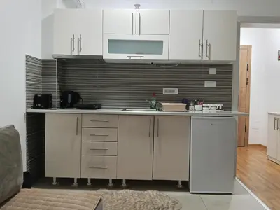 a kitchen with white cabinets and a counter top at Markovic san in Vrnjačka Banja