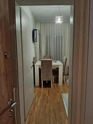 a room with a table and a chair and a television at Markovic san in Vrnjačka Banja