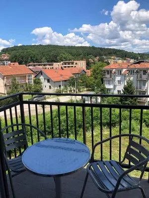 a table and chairs on a balcony with a view at Markovic san in Vrnjačka Banja