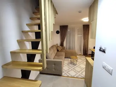 a living room with a spiral staircase in a living room at AlibiKopaonikSky32 in Kopaonik