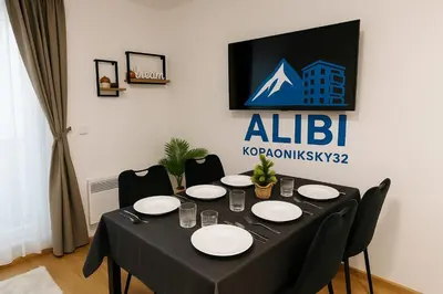 a black table with chairs and plates on it at AlibiKopaonikSky32 in Kopaonik