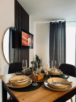a dining room table with plates and wine glasses at Apartman Nina in Kopaonik
