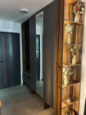 a hallway with a mirror and vases with flowers at Apartman Nina in Kopaonik