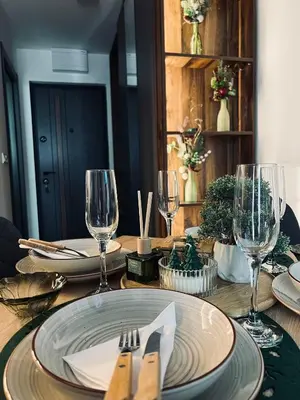 a wooden table with a plate and wine glasses at Apartman Nina in Kopaonik
