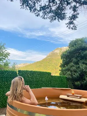 a woman sitting in a hot tub looking out at a mountain at Viva Sićevo