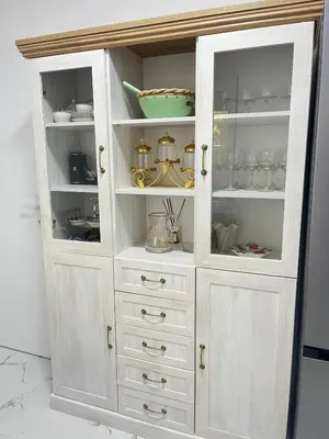 a white hutch with white drawers and dishes in it at Viva Sićevo
