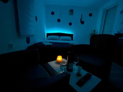 a dark room with a bed and a table with a candle at Avram019 in Zaječar