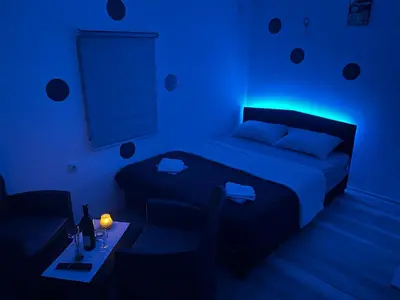 a blue room with a bed and a table in it at Avram019 in Zaječar