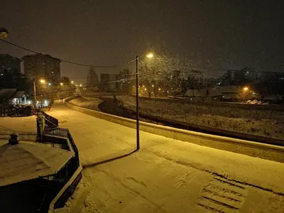 a snow covered street at night with a street light at River apartman Paraćin in Paraćin