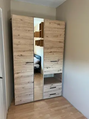 a large wooden closet with a mirror in a room at River apartman Paraćin in Paraćin