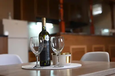 a bottle of wine and two wine glasses on a table at River apartman Paraćin in Paraćin