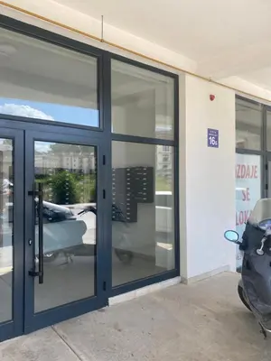 a store front with glass doors and a scooter parked outside at Apartman Adamović in Vrnjačka Banja
