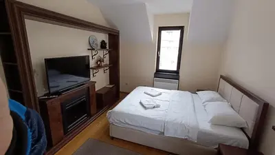 a bedroom with a bed and a flat screen tv at Vila Mecava Centar in Kopaonik