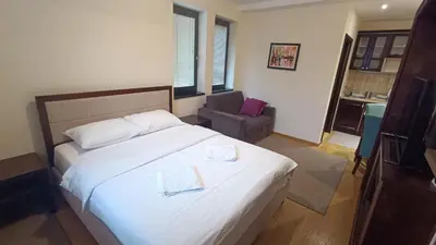 a bedroom with a bed and a chair in a room at Vila Mecava Centar in Kopaonik