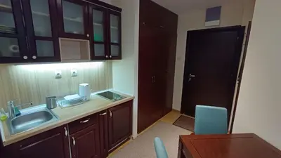 a kitchen with a sink and a table and a door at Vila Mecava Centar in Kopaonik