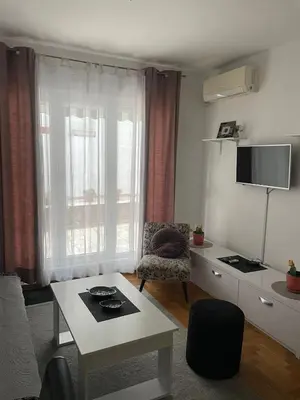 a living room with a table and a chair at Spice Apartment in Bukorovac