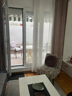 a living room with a chair and a table at Spice Apartment in Bukorovac