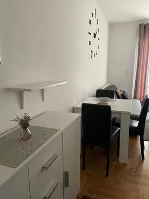 a white kitchen with a table and a dining room at Spice Apartment in Bukorovac