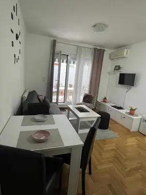 a living room with a table and chairs and a living room at Spice Apartment in Bukorovac