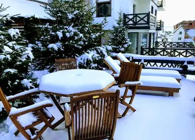 a table and chairs covered in snow in a yard at Apartments Casa Pavlovic in Kopaonik