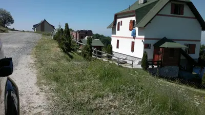 a house on a hill next to a dirt road at Apartments Casa Pavlovic in Kopaonik