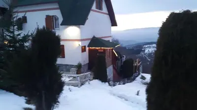 a white house with snow on the ground at Apartments Casa Pavlovic in Kopaonik
