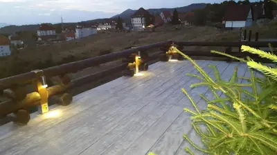 a wooden boardwalk with lights on top of a hill at Apartments Casa Pavlovic in Kopaonik
