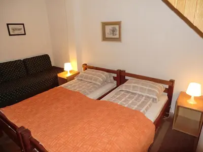 two beds in a room with a couch and two lamps at Holiday Home Minja in Kopaonik