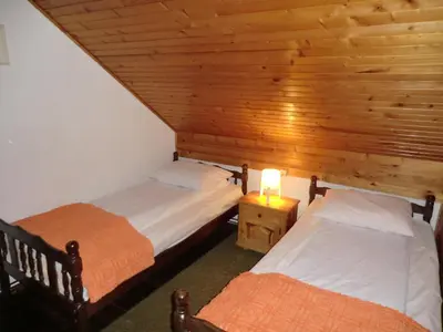 two beds in a room with a wooden ceiling at Holiday Home Minja in Kopaonik