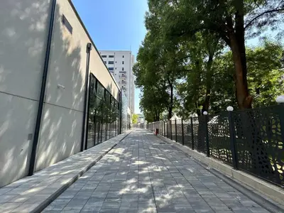 a sidewalk with a fence and trees on a street at Jagodina studio CRNJANSKI zatvoreni bazen in Jagodina