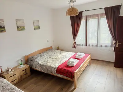 a bedroom with a bed with a red blanket at Deda Bocin konak