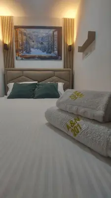 a bedroom with two beds and a painting on the wall at A&N President Kop in Kopaonik