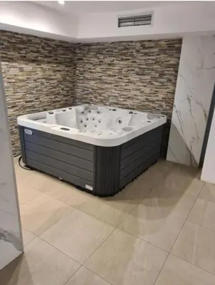 a large bath tub in a room with a brick wall at A&N President Kop in Kopaonik