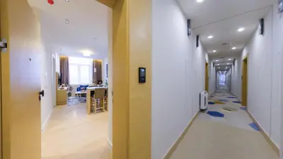a hallway with white walls and a yellow wall at Zepterme Harmony in Vrnjačka Banja