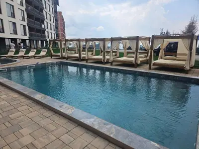 a swimming pool with lounge chairs in a building at Apartman SEVN in Kopaonik