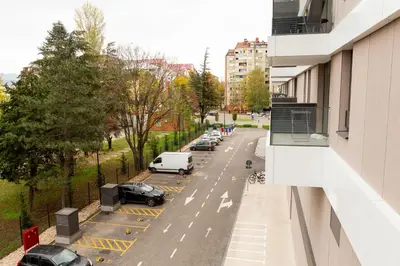 a city street with cars parked in a parking lot at Planet Gemini Residence & SPA in Niš